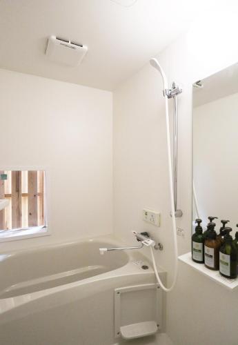 a bathroom with a bath tub with a shower at ORI stay and living in Kyoto