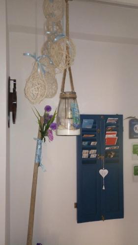 a room with a blue cabinet and a vase with flowers at ControVento Rooms in Margherita di Savoia