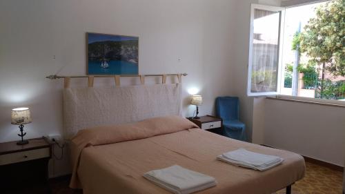 カーラゴノネにあるAppartamento Cala Gononeのベッドルーム1室(ベッド1台、タオル2枚付)