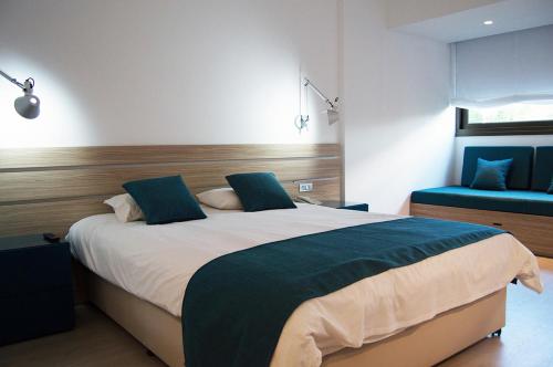 a bedroom with a large bed and a blue couch at Crystal Springs Beach Hotel in Protaras