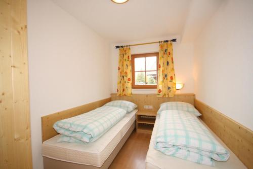 2 Betten in einem kleinen Zimmer mit Fenster in der Unterkunft Appartement Steinacher in Schladming