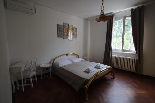 een slaapkamer met een bed, een tafel en een raam bij La Casa nel Bosco in Savio di Ravenna