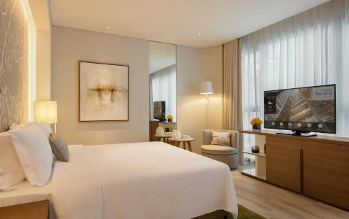 a bedroom with a bed and a flat screen tv at Al Bandar Arjaan by Rotana – Dubai Creek in Dubai