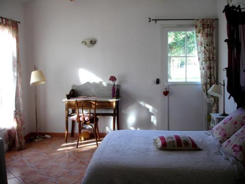 une chambre avec un lit, un bureau et une fenêtre dans l'établissement Gite de l'Amandari - classé 3 etoiles Prefecture - piscine chauffée privative, terrasses et jardin, 5 minutes à pied du village, au Plan-de-la-Tour