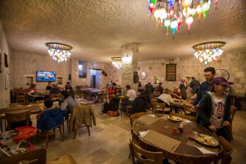 a group of people sitting at tables in a restaurant at Hera Cave Suites in Goreme