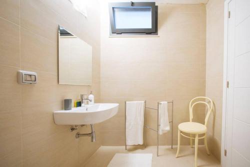a bathroom with a sink and a mirror and a stool at Paolo & Francesca's Trapani Loft in Trapani
