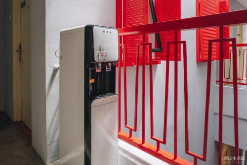 una nevera pequeña en una habitación con barras rojas en HOTEL CIQ, JALAN TRUS, en Johor Bahru