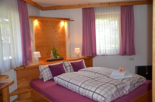 una camera con letto e testiera in legno di Ferienwohnung Annemarie a Virgen