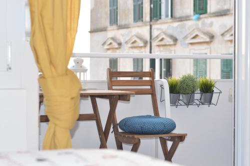 balcón con mesa, silla y ventana en Nora Rooms, en Zadar