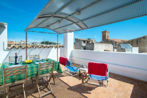 eine Terrasse mit einem Tisch und Stühlen auf dem Balkon in der Unterkunft Owl Booking Villa Padrina - Walking to the Old Town in Pollença
