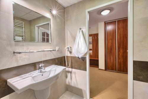 ein Badezimmer mit Waschbecken und Spiegel in der Unterkunft Hotel Renesans in Zamość