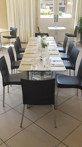 a long table with chairs and glasses on it at The Playhouse Hotel in Barraba