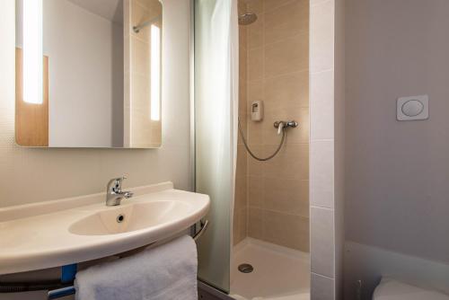uma casa de banho com um lavatório e um chuveiro em B&B HOTEL Vannes Ouest Golfe du Morbihan em Vannes