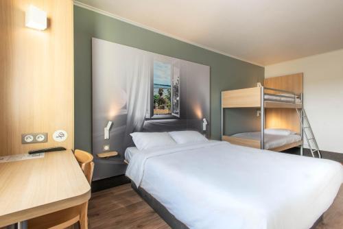 ein Schlafzimmer mit einem Bett und einem Etagenbett in der Unterkunft B&B HOTEL Vannes Ouest Golfe du Morbihan in Vannes