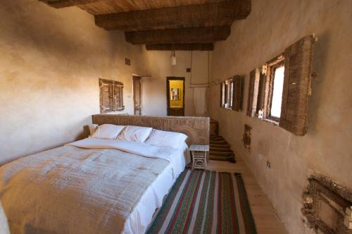 ein Schlafzimmer mit einem Bett und eine Treppe mit Fenstern in der Unterkunft Albabenshal Lodge Siwa in Siwa
