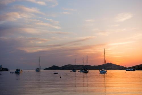 a group of boats in the water at sunset at Vourkari Village in Vourkarion