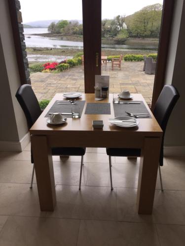 a wooden table with chairs around it with a view at Seafort Luxury Hideaway in Bantry