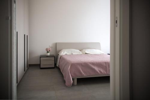 - une chambre avec un lit doté d'une couverture rose et d'une table de chevet dans l'établissement CHICCO DI CAFFE', à Monopoli