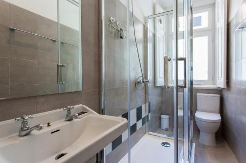 a bathroom with a sink and a toilet and a shower at Caraujo Apartments in Lisbon