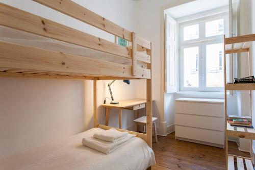 a small bedroom with a bunk bed and a window at Caraujo Apartments in Lisbon