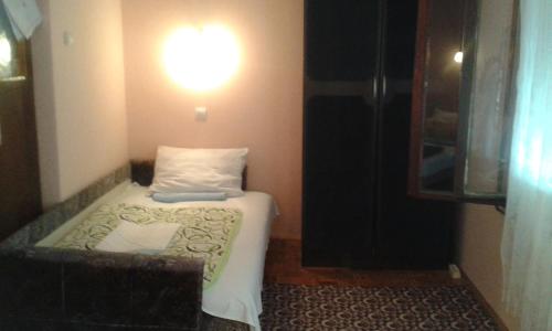 um pequeno quarto com uma cama e uma luz na parede em Apartman Vesna em Ovcar Banja