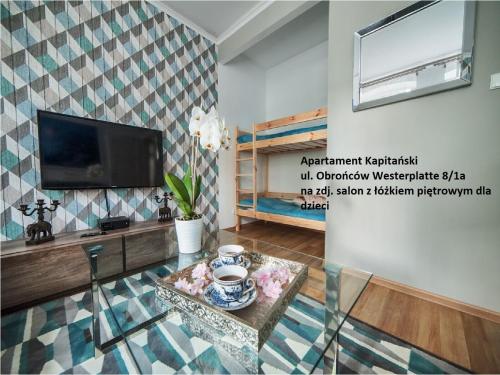 a living room with a television and a table at Sopot Spa Apartament in Sopot