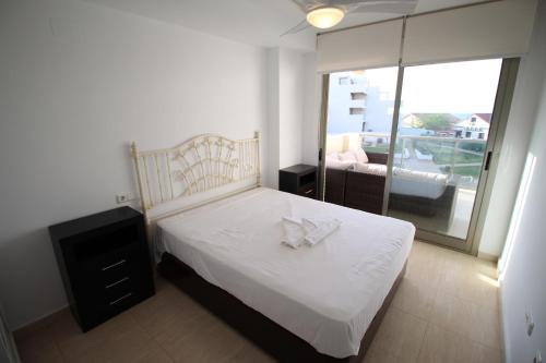 デニアにあるTierra de Mar 26のベッドルーム1室(白いシーツ付きのベッド1台、窓付)