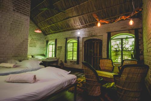 Cette chambre comprend 2 lits, des chaises et des fenêtres. dans l'établissement Shannu's Ranch Inn, à Pushkar