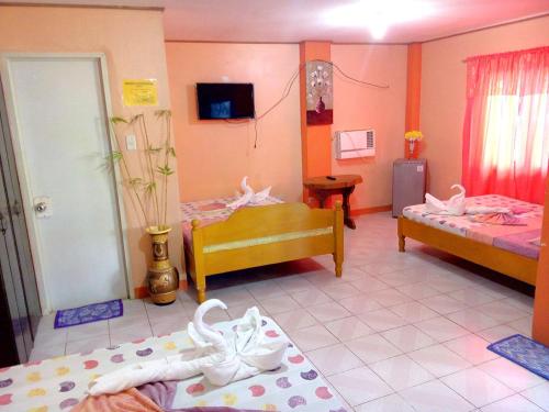 a room with two beds and shoes on the floor at Jun and Carol Beach Cottages in Pagudpud