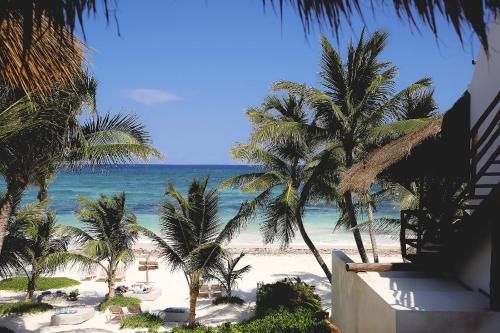 a view of a beach with palm trees and the ocean at Cabanas Tulum- Beach Hotel & Spa in Tulum