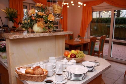 a table with plates and bowls of fruit on it at Hotel-Garni Elbgarten Bad Schandau in Bad Schandau