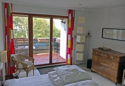 una camera con letto e cassettiera e un balcone di An den Isarauen a Grünwald