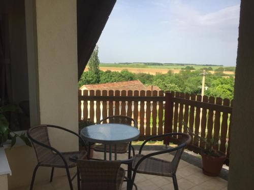 a table and chairs on a balcony with a view at Baranya Apartman in Áta