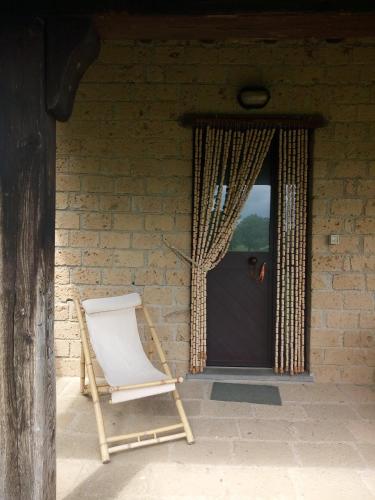 a wooden chair sitting in front of a door at Agriturismo Podernuovo in Acquapendente