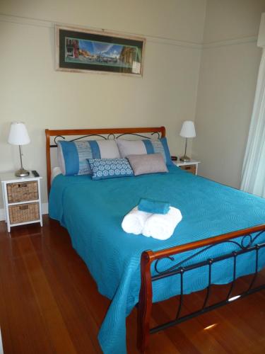 a bedroom with a blue bed with two towels on it at Shepp Central Apartment in Shepparton