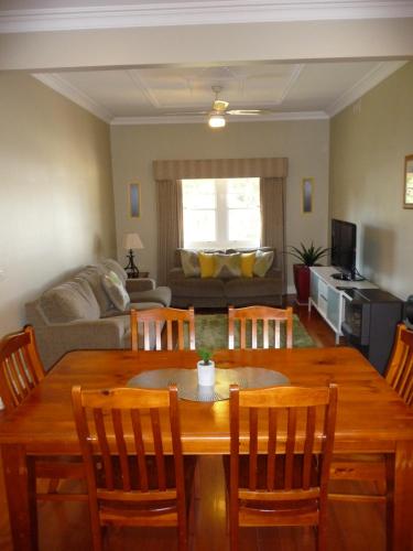 a living room with a wooden table and chairs at Shepp Central Apartment in Shepparton
