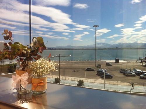 a vase of flowers on a table with a view of a parking lot at Hotel Bahía in Santander