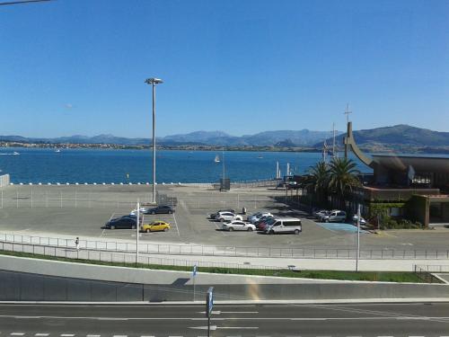 a parking lot with cars parked next to a body of water at Hotel Bahía in Santander