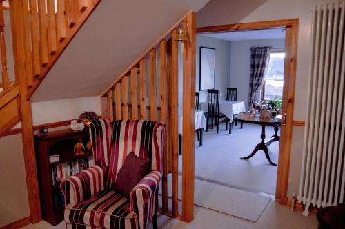 a living room with a staircase with a chair and a table at Davar in Lochinver