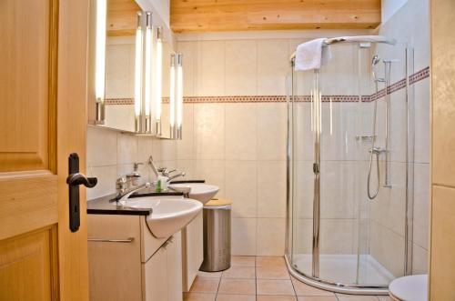 ein Bad mit 2 Waschbecken und einer Dusche in der Unterkunft Apartment Brunnen - GRIWA RENT AG in Grindelwald