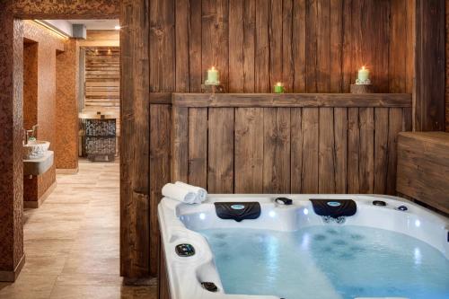 a bath tub in a bathroom with a wooden wall at Dvůr Pecínov in Benešov