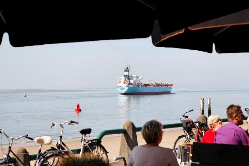 a large boat with people on it near a beach at Hotel De Leugenaar in Vlissingen