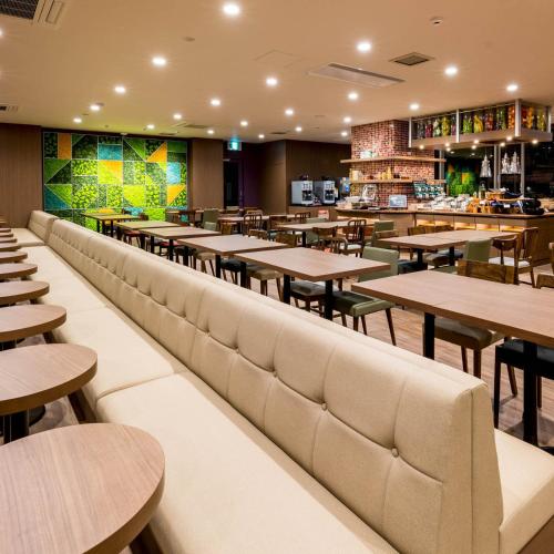 a restaurant with tables and chairs and a bar at Super Hotel Premier Musashi Kosugi Ekimae in Kawasaki