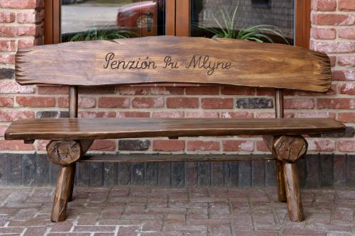 a wooden bench sitting in front of a building at Penzión Pri Mlyne in Nitra