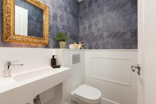 a bathroom with a sink and a toilet and a mirror at Enjoybcn Coliseum Apartments in Barcelona