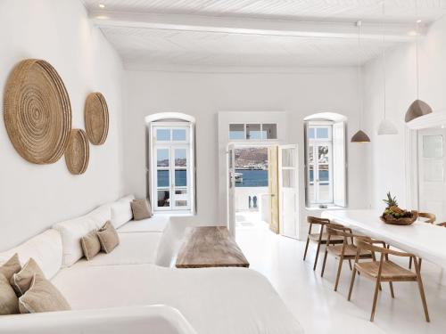 Villa Kampani Sea View Villa Mykonos Town في مدينة ميكونوس: غرفة معيشة بيضاء مع أريكة بيضاء وطاولة