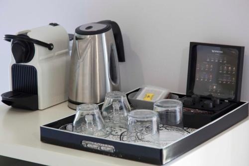 a tray with glasses and a coffee maker on a counter at Shalom Luxury Rooms Kondilaki in Chania