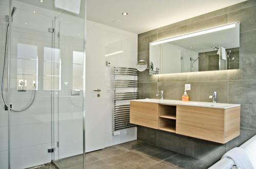 a bathroom with a sink and a shower at Apartment Fortuna 5.5 - GriwaRent AG in Grindelwald