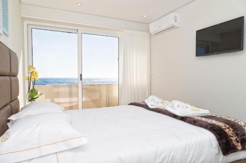 una camera bianca con un letto e una grande finestra di BestVillas Âncora Mar a Vila Praia de Âncora