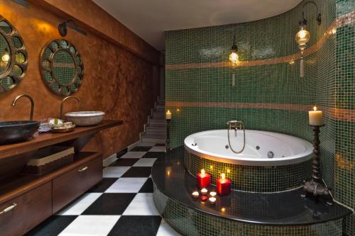 イスタンブールにあるSokullu Pasa Hotel - Special Classのバスルーム(キャンドルと緑のタイルのバスタブ付)